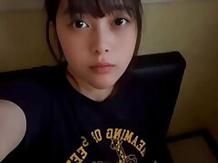 A female school college girl drains alone in a intimate bedroom at a karaoke bar, using a technique she has just learned.