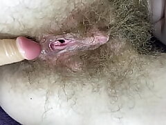 Fur covered woman smashes her humid good-sized clit pussy with dildo in close up